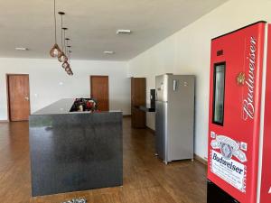 a kitchen with a counter and a refrigerator in a room at Rancho Vida Boa em Miguelopolis in Miguelópolis