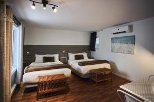 a hotel room with two beds and a table at Motel Boutique Hygge - anciennement Aux Portes du Soleil in Baie-Saint-Paul +48 photos