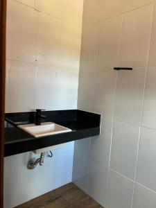 a bathroom with a sink and a black counter at Rancho Vida Boa em Miguelopolis in Miguelópolis +8 photos