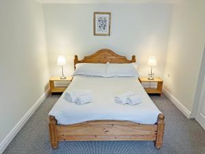a bedroom with a large bed with two night stands at Rose Cottage - Uk51373 in Winston