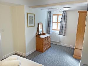 a bedroom with a dresser and a mirror and a window at Rose Cottage - Uk51373 in Winston