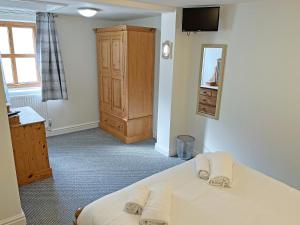 a bedroom with a bed with two towels on it at Rose Cottage - Uk51373 in Winston +3 photos