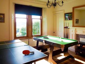 a living room with a pool table and a window at Aldersyde in Tighnabruaich