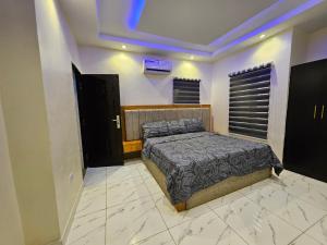 a bedroom with a bed in a room at Less2More Luxury Suites in Agege