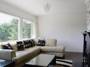 a living room with a couch and a window at Carnethy in Tighnabruaich