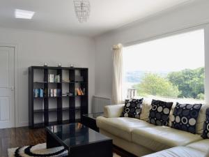 a living room with a couch and a book shelf at Carnethy in Tighnabruaich