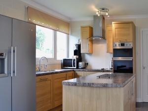 a kitchen with wooden cabinets and a counter top at Carnethy in Tighnabruaich