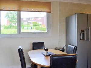 a room with a table and chairs and a refrigerator at Carnethy in Tighnabruaich