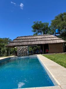 a house with a swimming pool and a building at Quincho El Milagro in Camba Punta