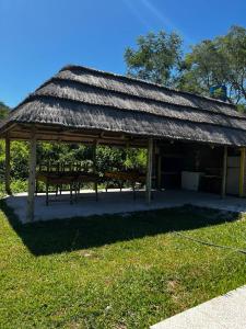 a pavilion with a grass roof on the grass at Quincho El Milagro in Camba Punta