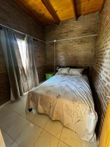 a bedroom with a bed in a brick wall at Quincho El Milagro in Camba Punta