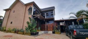a house with a car parked in front of it at Bati Valley Guest House in Kigali