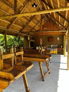 a group of wooden benches sitting inside of a building at Quincho El Milagro in Camba Punta