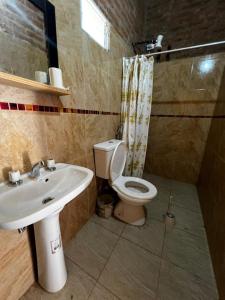 a bathroom with a toilet and a sink at Quincho El Milagro in Camba Punta +25 photos