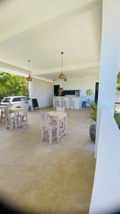 a room with tables and chairs and a kitchen at Evara Hill Homestay in Uluwatu