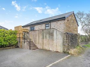 an old brick building with a stone wall and stairs at Mabels Stable in Clitheroe