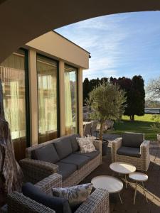 a patio with a couch and chairs and tables at Hotel Garni Klaret in Valtice