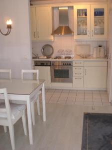 a kitchen with a white table and a stove top oven at Morgensünn am Strand in Kühlungsborn