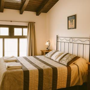 a bedroom with a bed with a striped blanket at APARTAMENTOS MARIAJE in Barro de Llanes