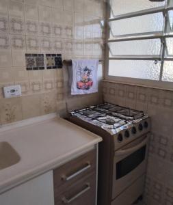a small kitchen with a stove and a window at Ap do Edney Águas de Lindoia in Águas de Lindoia