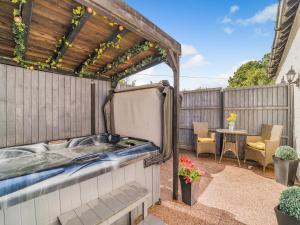 a hot tub in a backyard with a pergola at Coachmans Cottage - Uk50418 in Bisterne