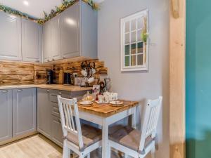 a kitchen with a wooden table and two chairs at Coachmans Cottage - Uk50418 in Bisterne