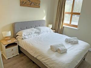 a bedroom with a bed with towels on it at Willow Cottage - Uk51376 in Winston