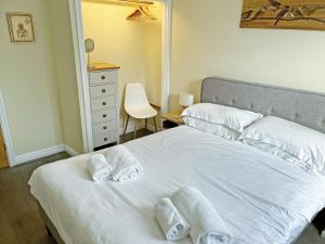 a bedroom with a white bed with towels on it at Willow Cottage - Uk51376 in Winston