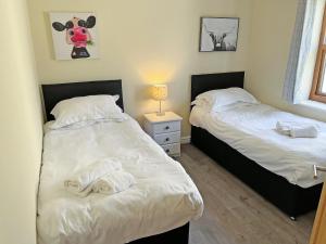 two beds in a bedroom with towels on them at Willow Cottage - Uk51376 in Winston