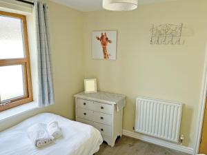 a bedroom with a bed and a dresser and a window at Willow Cottage - Uk51376 in Winston +4 photos