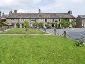 a house with a fence in front of a street at Clematis Cottage in Burnsall