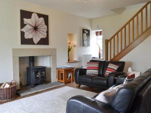 a living room with a couch and a fireplace at Clematis Cottage in Burnsall +11 photos