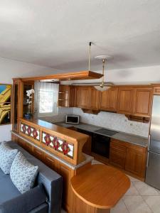 a kitchen with wooden cabinets and a table and a couch at Peramos Luxury 2 in Nea Peramos
