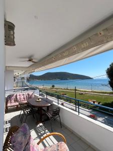 a balcony with a table and chairs and a view of the ocean at Peramos Luxury 2 in Nea Peramos