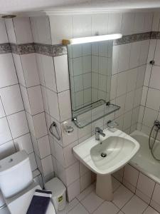 a bathroom with a sink and a toilet and a mirror at Peramos Luxury 2 in Nea Peramos +4 photos