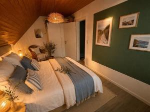 a bedroom with a large bed with a green wall at Ferienhaus Deichkrone in Dornum
