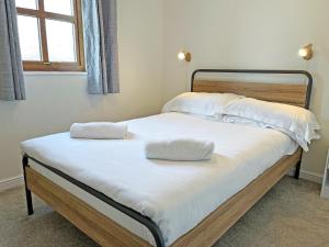 a bed with two pillows on it in a bedroom at Ivy Cottage - Uk51372 in Winston