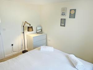 a bedroom with a white bed and a lamp at Ivy Cottage - Uk51372 in Winston +5 photos
