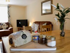 a table with bread and other items on it at Hen Ysgubor - 29518 in Fairbourne