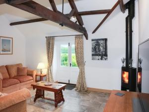 a living room with a couch and a wood stove at The Cottage in South Barrow