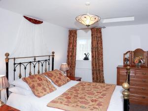 a bedroom with a bed and a dresser and a window at The Cottage in South Barrow