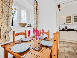 a wooden table with plates and wine glasses on it at The Cottage in South Barrow