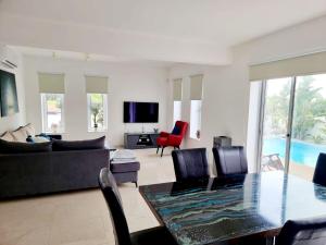 a living room with a couch and a table with chairs at luxury villa utopia 2 in Paphos