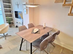 a dining room with a wooden table and chairs at Ferienhaus Villa Seeblick - ABC223 in Bad Kleinen
