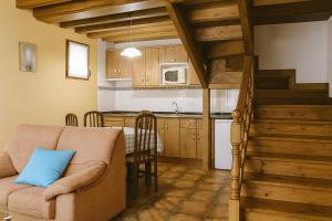 a living room with a couch and a kitchen at APARTAMENTOS MARIAJE in Barro de Llanes