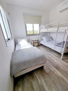 a bedroom with two bunk beds and a wooden floor at luxury villa utopia 2 in Paphos +34 photos