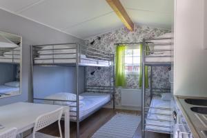 a room with three bunk beds and a table at Djulöcamping in Katrineholm