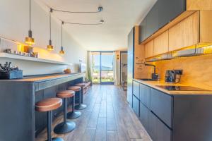 a kitchen with wooden cabinets and bar stools at SOL Y LUNA 11 Apartment in Sardinia close to the beach and to Olbia airport in Olbia
