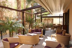 un patio con sofás, mesas y sillas en Hotel Il Portico en Favignana