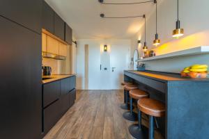 a kitchen with black cabinets and bar stools at SOL Y LUNA 11 Apartment in Sardinia close to the beach and to Olbia airport in Olbia
